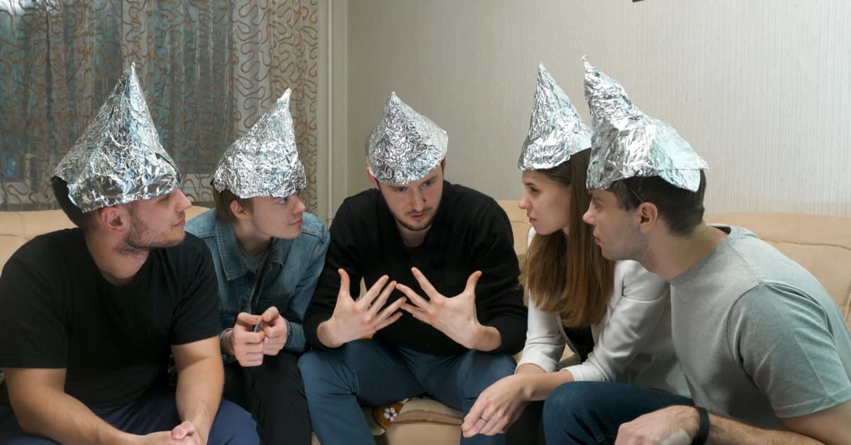 group of people discussing a conspiracy theory while wearing tin foil hats